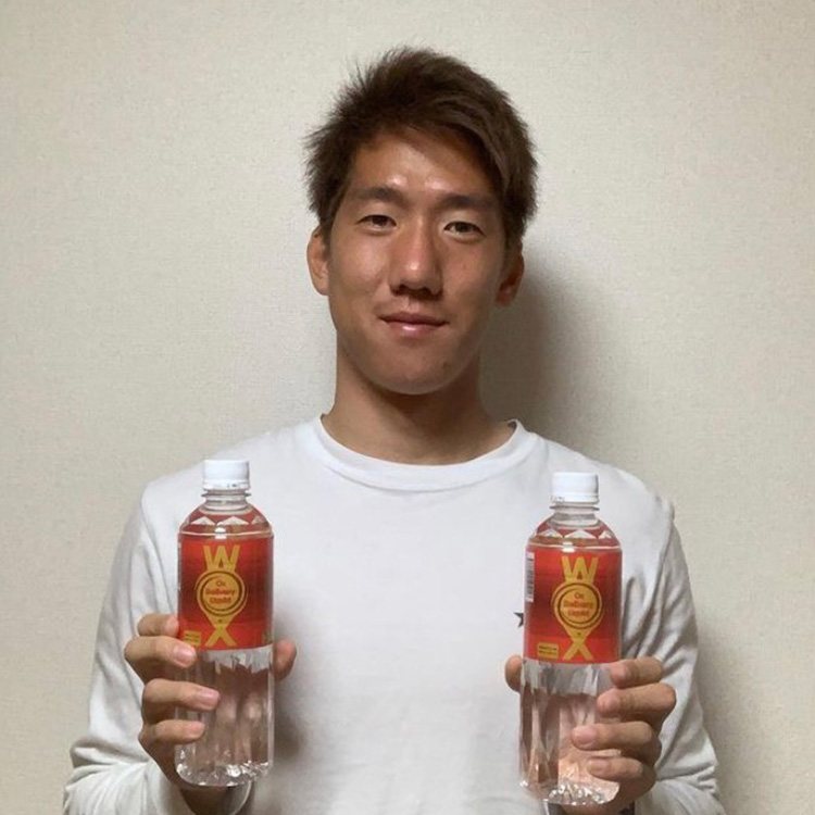 Professional soccer player holding two bottles of WOX