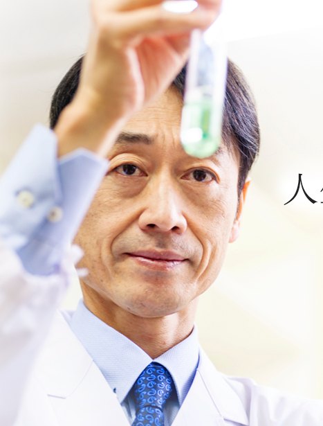 Takaaki Matsumoto in a lab coat holding a test tube to the light