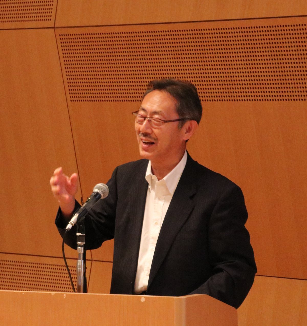 Takaaki Matsumoto speaking at a lectern