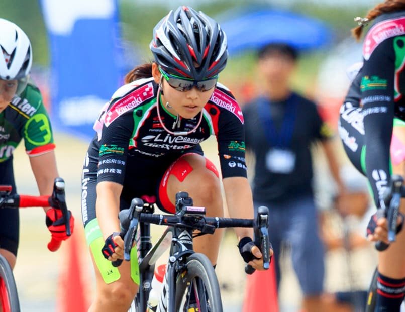 Road cyclists mid-race, Team WOX rider in the pack